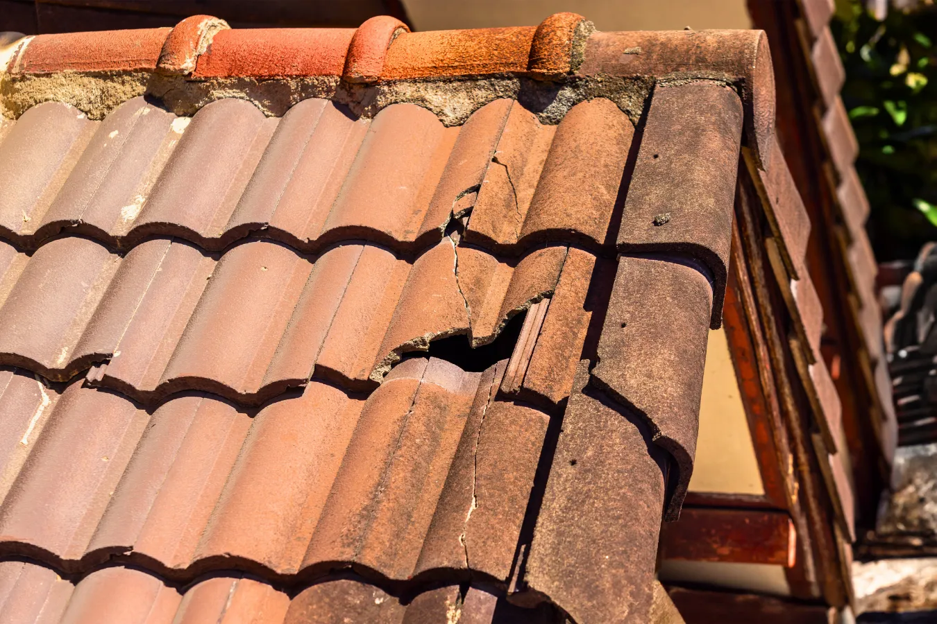 Cracked concrete roof tiles causing potential water intrusion and roof leaks in Naples, Florida.