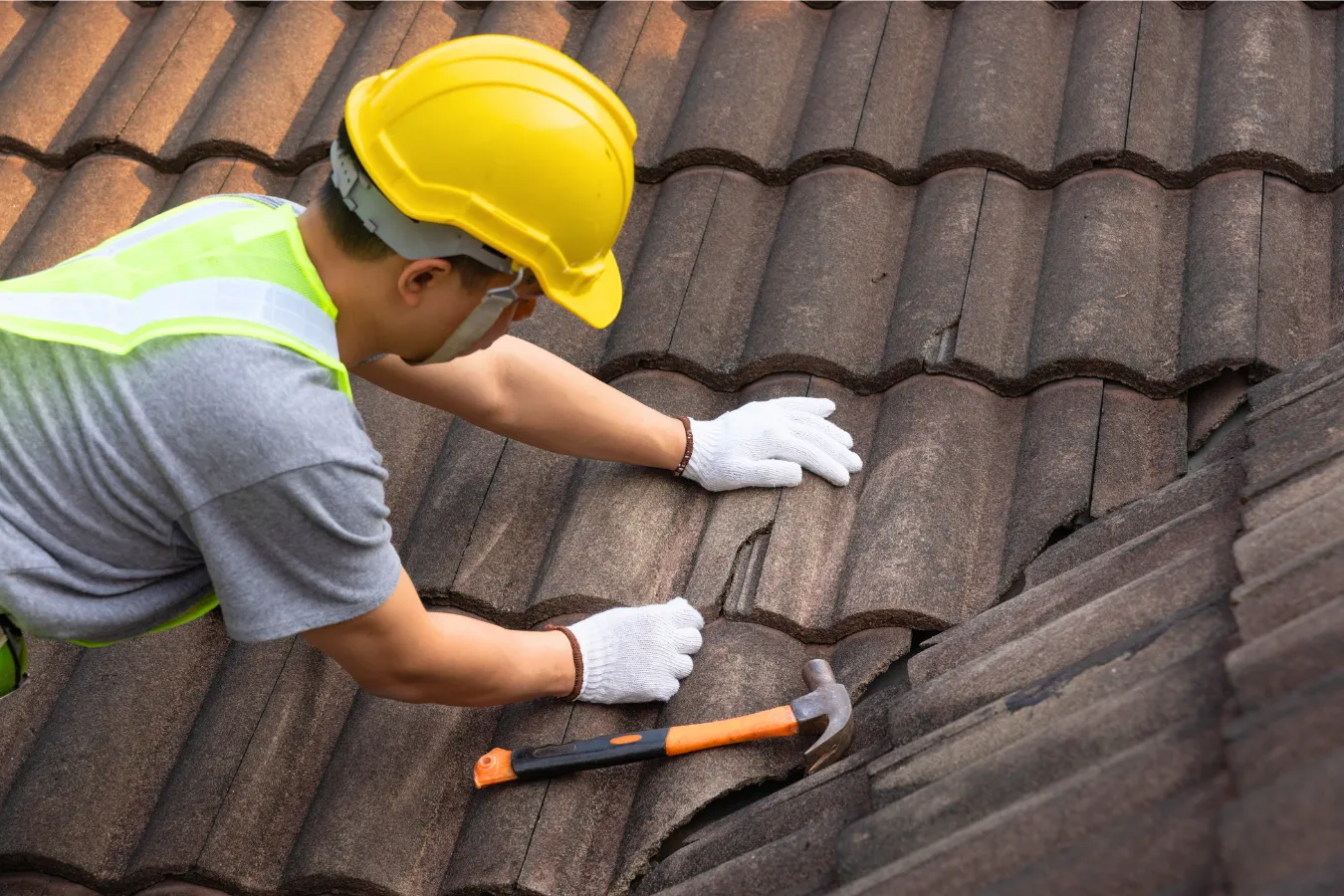 Roofing technician performing preventative roof maintenance and inspection on a residential roof