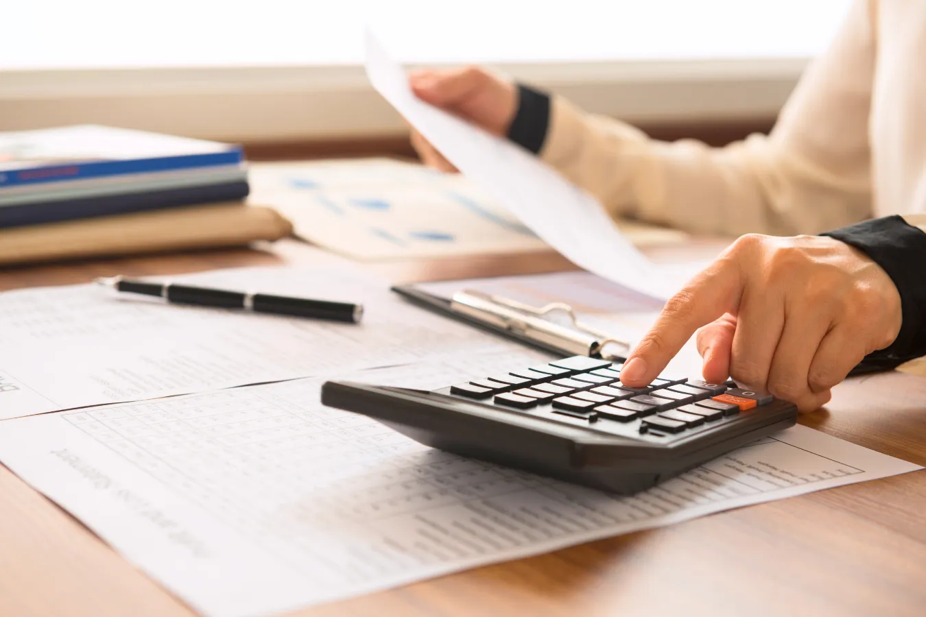 Homeowner calculating roof repair costs compared to expensive structural damage from delayed repairs.