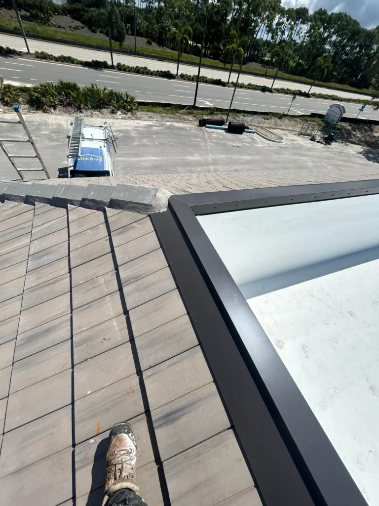 Metal roof flashing between the concrete tile and TPO roofing at Plaza Halstatt
